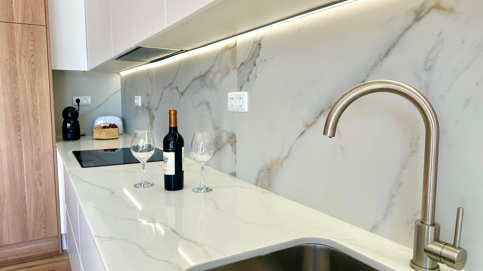 Bancada em mármore com torneira e placa de indução