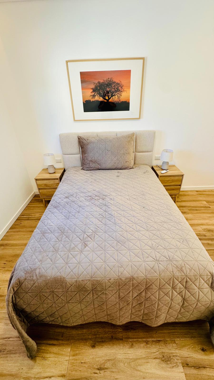 Quarto com cama de casal e candeeiros nas mesas de cabeceira