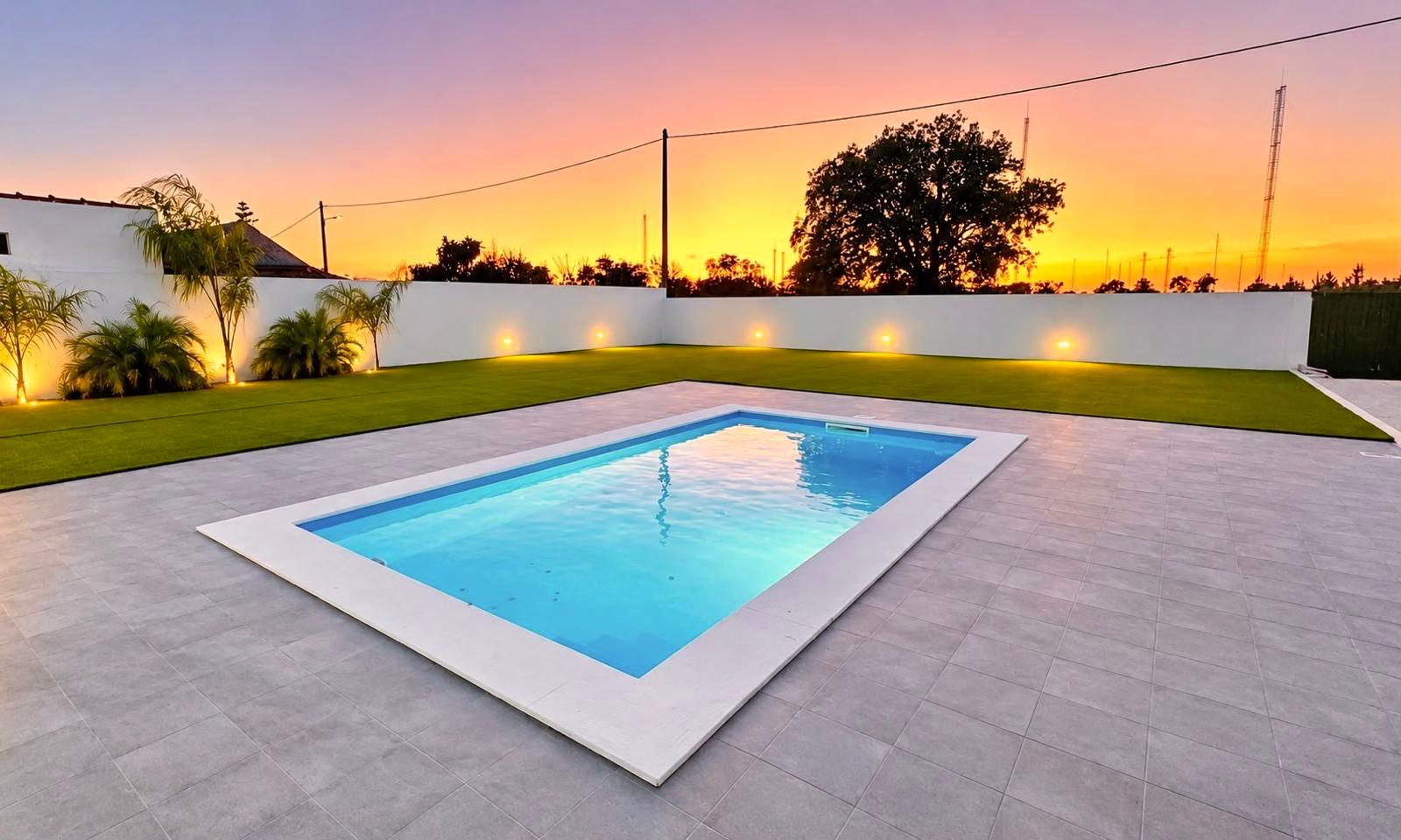 Piscina iluminada ao pôr do sol