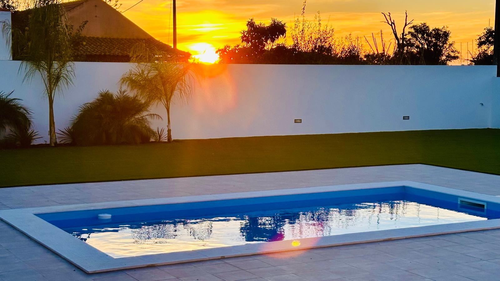 Pôr do sol a refletir-se na piscina