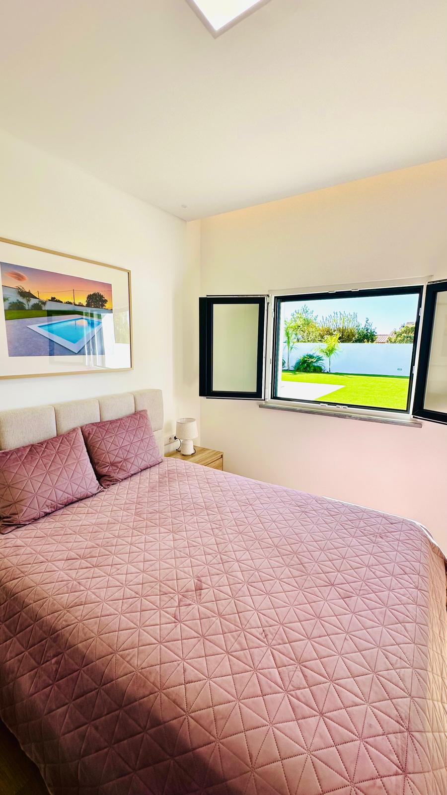 Quarto com janela aberta para o jardim e as palmeiras